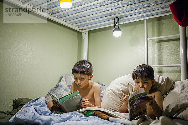 Zwei japanisch-amerikanische Jungen lesen Bücher im Bett