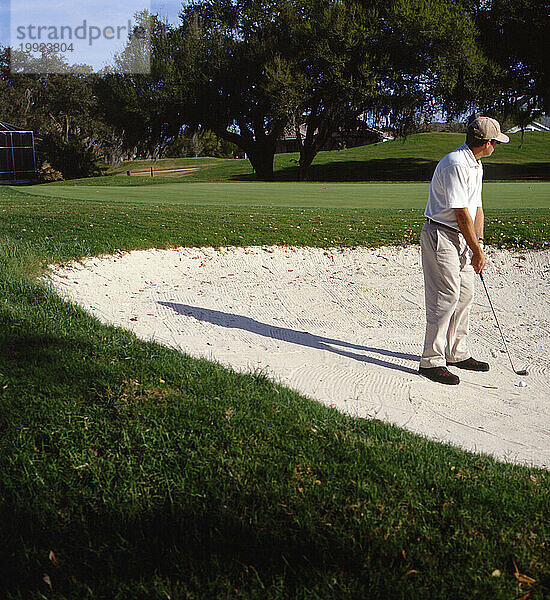 Mann auf Golfplatz im Sandfang.