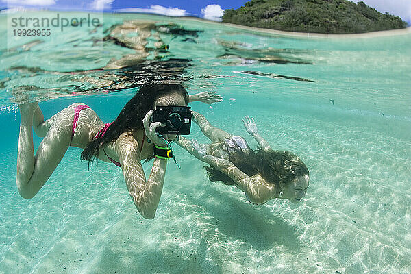 Mädchen schwimmen und haben Spaß im Wasser in der Waimea Bay.