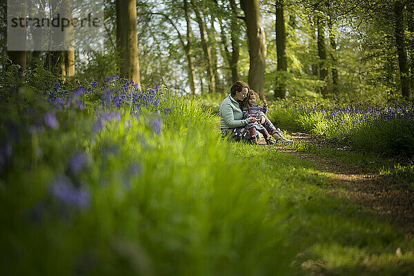Eine Frau und ein junges Mädchen saßen in Glockenblumen