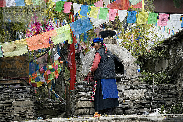 Tibetische Frau und Gebetsfahnen in der Provinz Yunnan  China.