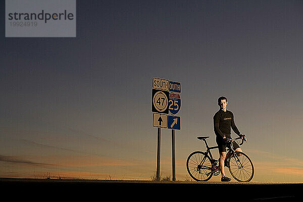 Ein Mann hält an einem Straßenschild an  während er mit dem Fahrrad in Albuquerque  New Mexico  unterwegs ist.