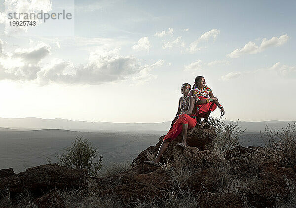 Zwei kenianische Safariführer ruhen auf einem Felsen.