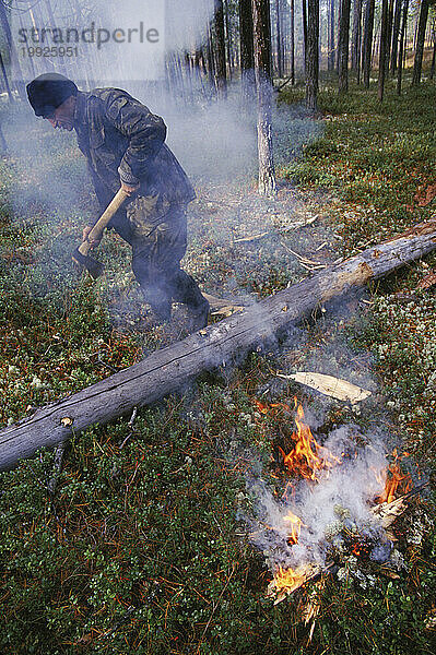 Mann steht im Rauch zum Schutz vor Mücken  Sibirien  Russland.