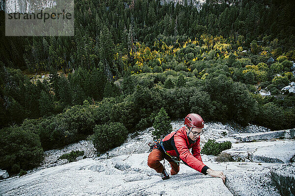 Ein Mann klettert Pitch 1 auf The Grack (5.6) im Yosemite Valley.