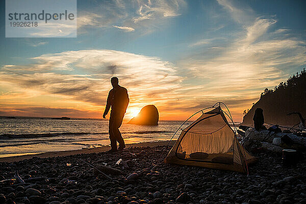 Silhouette eines Mannes  der auf einem Campingplatz am Strand im Olympic National Park steht