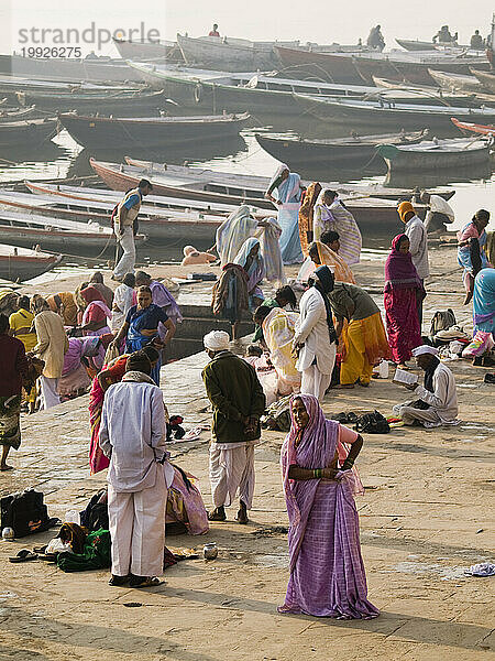 Frauen hüllen sich in ihre Saris  nachdem sie sie am heiligen Fluss Ganges gewaschen haben.