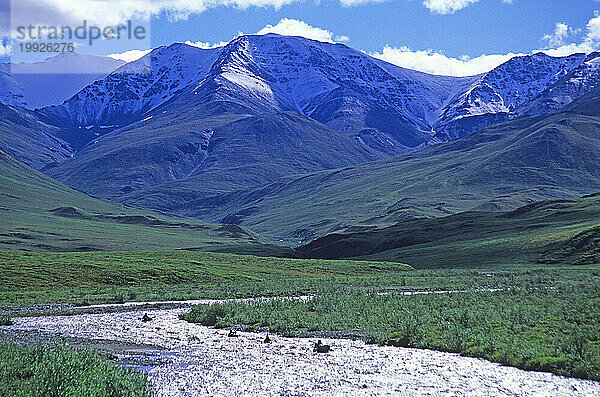 Vier Kajakfahrer paddeln auf einem Fluss vor den Bergen im Arctic National Wildlife Refuge  Alaska.