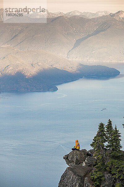 Mann auf einem Berg mit Blick auf das Meer und die Berge  Vancouver