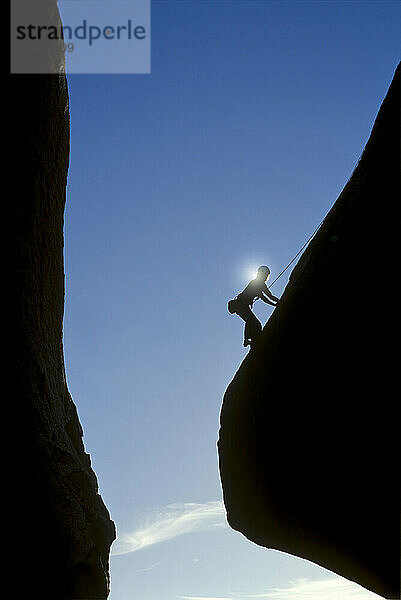 USA: Kalifornien: Silhouette eines Kletterers beim Bouldern in den Buttermilks bei Sonnenaufgang