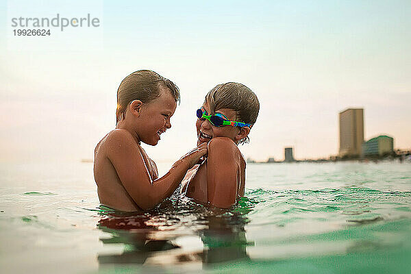 Zwei kleine Jungen spielen zusammen im Meer