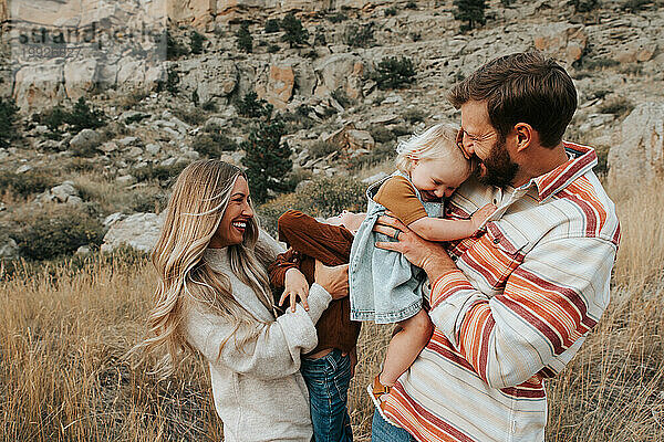Eine vierköpfige Familie lacht an einem Herbsttag zusammen