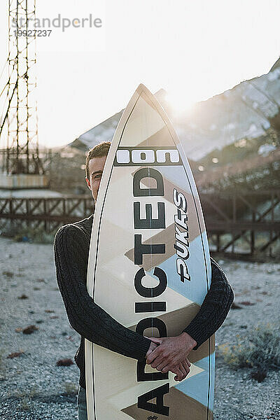 Porträt eines Surfers  der sein Surfbrett umarmt  Teneriffa  Kanarische Inseln  Spanien