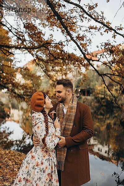 Ein Mann und eine Frau in Mänteln gehen bei einem Date durch einen Herbstpark