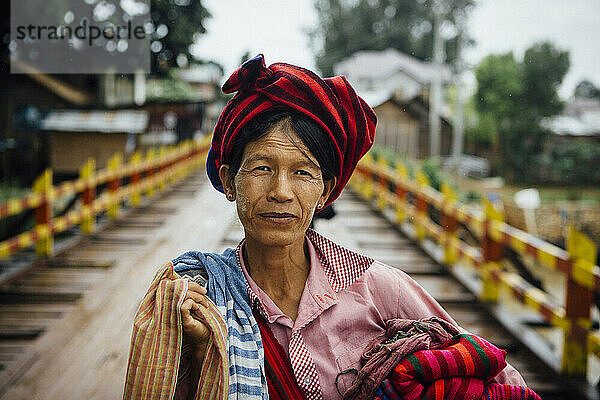 Porträt einer Kunsthandwerksverkäuferin  die Produkte im Tempelkomplex in der Nähe des Inle-Sees  Shan-Staat  Myanmar  verkauft