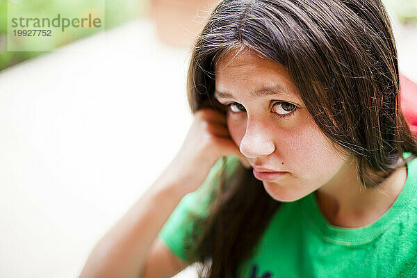 Ein 15-jähriges Mädchen blickt verärgert und frustriert in die Kamera.