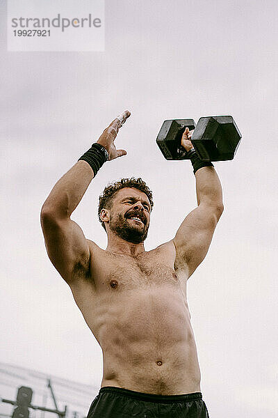 CrossFit-Wettbewerb für Männer. Ein Mann hebt eine Hantel.