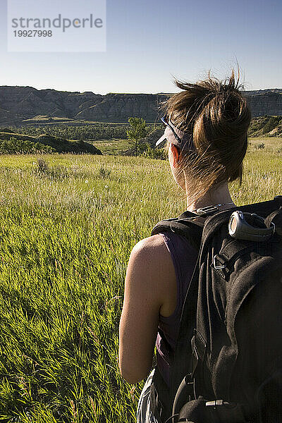 Eine erwachsene Frau wandert in einem Nationalpark in North Dakota mit dem Rucksack.