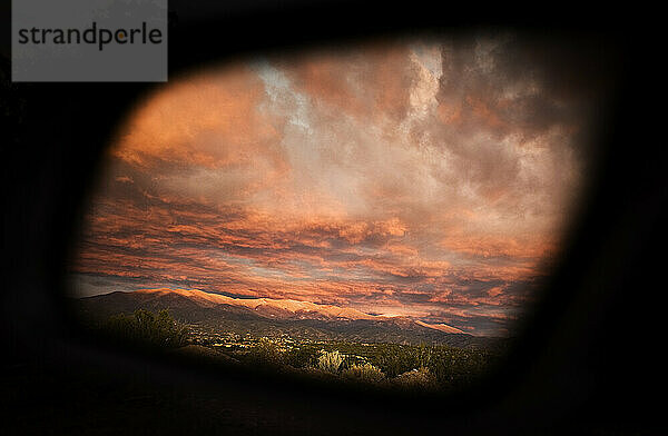 Der Wintersonnenuntergang in Santa Fe  NM spiegelt sich im Seitenfenster eines Autos.