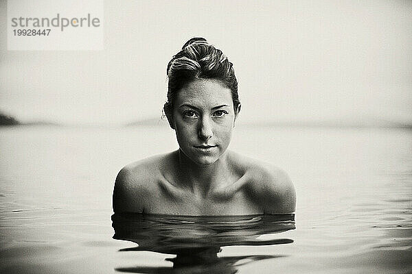 Eine schöne junge Frau posiert für ein Porträt beim Schwimmen im Lake Saint George  Maine.