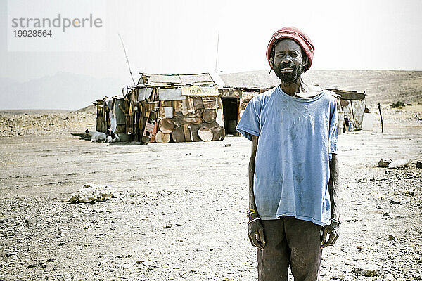 Ein Mann steht vor seinem Haus in Namibia
