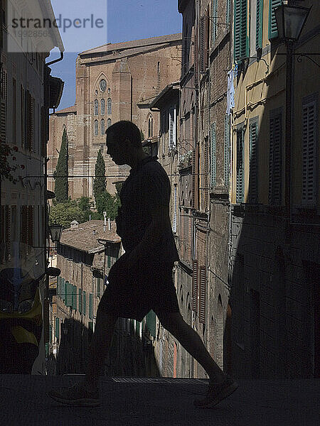 Die Silhouetten und Schatten von Fußgängern in Siena  Italien.