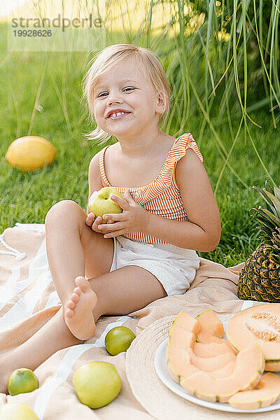 Zeit  Obst zu essen  süßes blondes Mädchen  das Äpfel bei einem Picknick isst