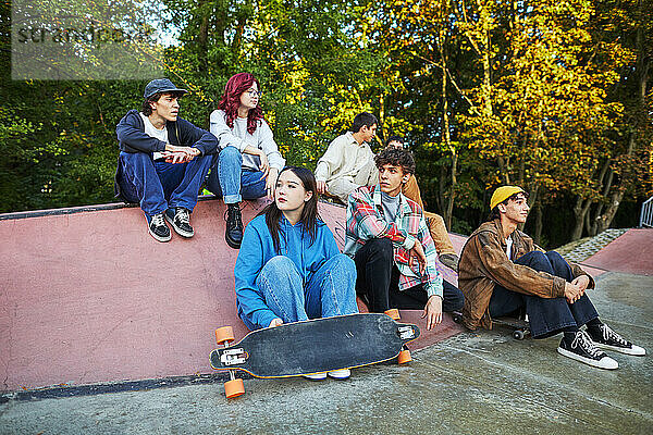 Eine Gruppe junger Leute sitzt in einem Skatepark