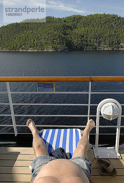 Ein Tourist entspannt sich auf einem Boot entlang des Saguenay River in Kanada.