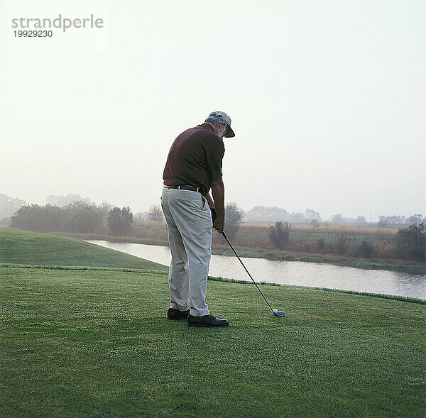 Mann auf Golfplatz - früher Morgen.