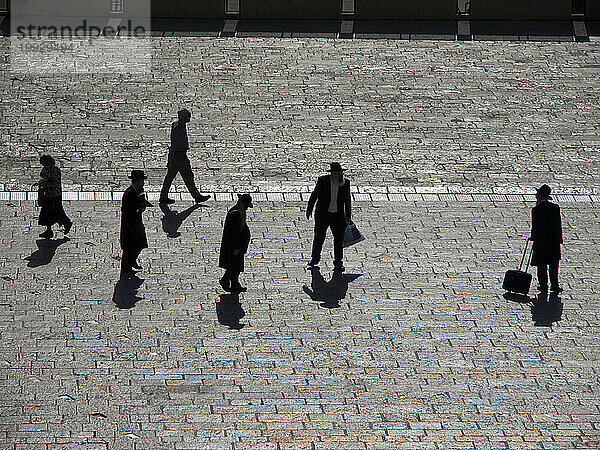 Silhouetten entfernter Menschen auf einer Straße in Israel.