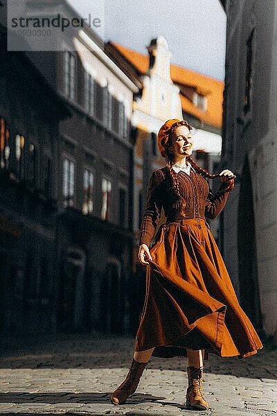 Junge Frau in Retro-Kleidung in der Sonne in einer alten europäischen Stadt