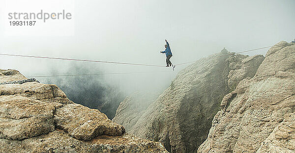 Mann geht Highline in Canyon.