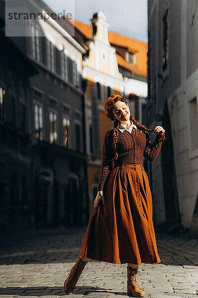 Junge Frau in Retro-Kleidung in der Sonne in einer alten europäischen Stadt