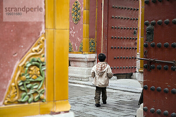 Ein Junge erkundet einen Palast in Peking  China.