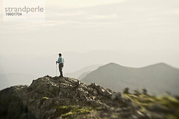 Ein Wanderer steht auf dem Gipfel des West Peak  Bigelow Mountain  Maine.