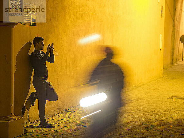 Silhouette eines Mannes  der mit seinem Handy auf der Straße in Marrakesch  Marokko  läuft.