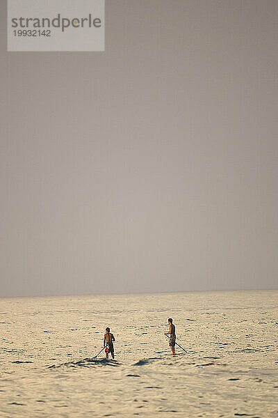 Zwei Personen stehen beim Stand-Up-Paddle-Surfen am Rocky Point an der Nordküste von Hawaii am 11.02.07