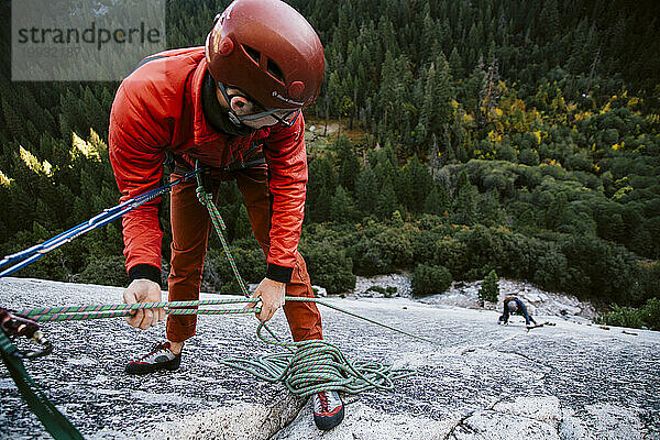 Ein Kletterer sichert sich am Gipfel von Pitch 2 auf The Grack (5 6) im Yosemite Valley.