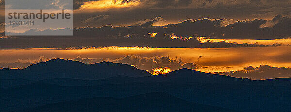 Wunderschöner Sonnenuntergang über den Silhouetten der Berge