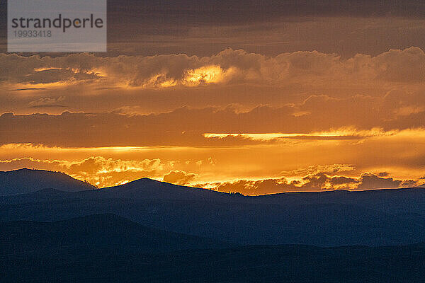 Wunderschöner Sonnenuntergang über den Silhouetten der Berge