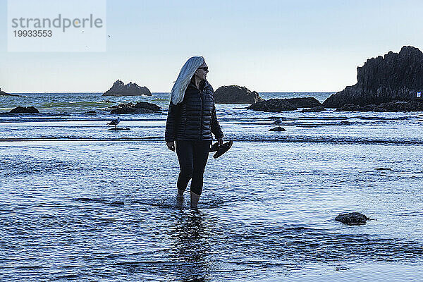 USA  Oregon  Frau watet im Meer am Cannon Beach