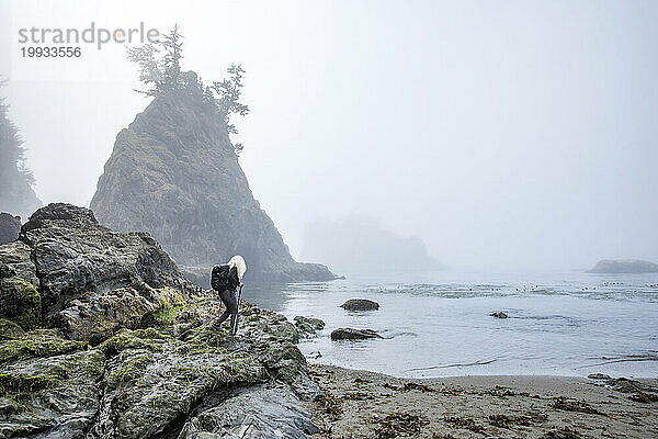 USA  Oregon  Brookings  Seniorin wandert auf Felsen über dem Meer