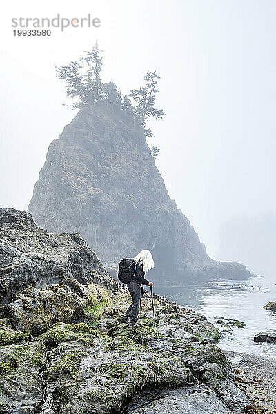 USA  Oregon  Brookings  Seniorin wandert auf Felsen über dem Meer