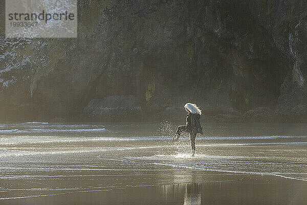 USA  Oregon  Newport  Frau planscht im seichten Wasser am Strand