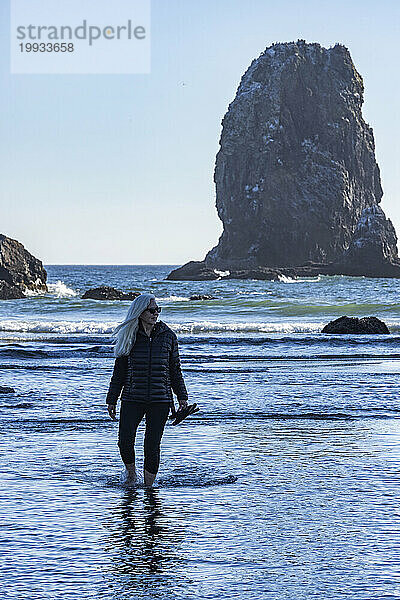 USA  Oregon  Frau watet im Meer am Cannon Beach