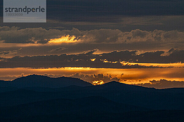 Wunderschöner Sonnenuntergang über den Silhouetten der Berge