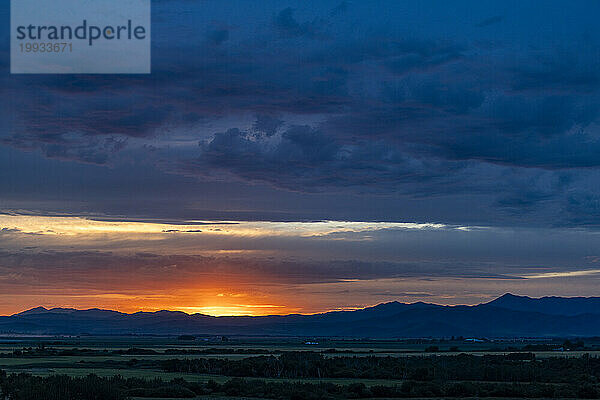 Wunderschöner Sonnenuntergang über den Silhouetten der Berge