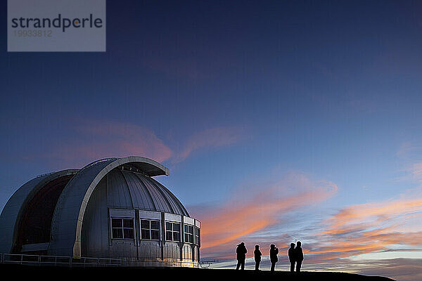 Silhouette von Menschen  die den Sonnenuntergang am Observatorium beobachten