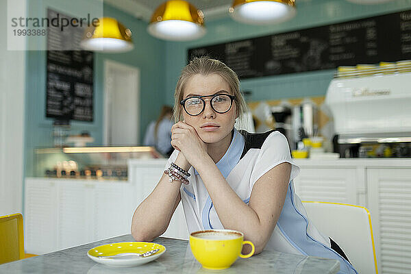 Porträt einer ernsthaften Frau  die im Café sitzt